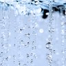 Eine Nahaufnahme von fallendem Wasser, das in der Luft schwebt und dabei glitzernde Reflexionen erzeugt.