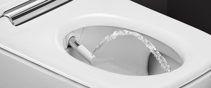 Ein modernes Bidet mit einem Wasserstrahl, der aus der Düse in die Toilettenschüssel spritzt, auf einem weißen Hintergrund.