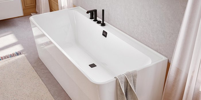 Eine moderne Badewanne aus weißem Material steht in einem hellen Badezimmer mit sanften Lichtstrahlen.